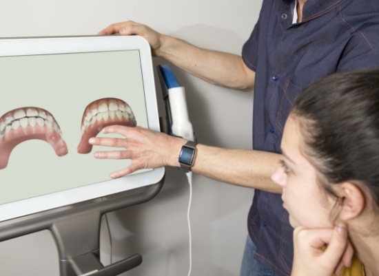 Dentist and patient looking at images demonstrating the Invisalign process