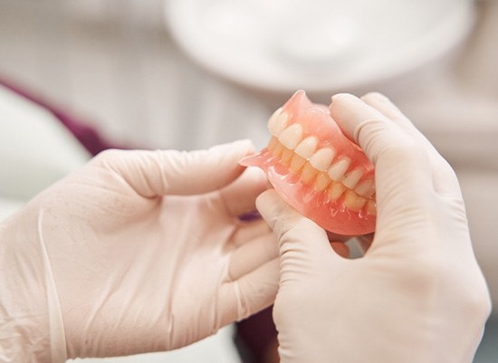 Dentist holding full dentures