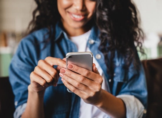 Woman using smartphone to request a dental appointment