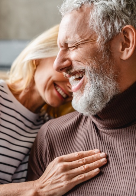 Man and woman smiling after restorative dentistry