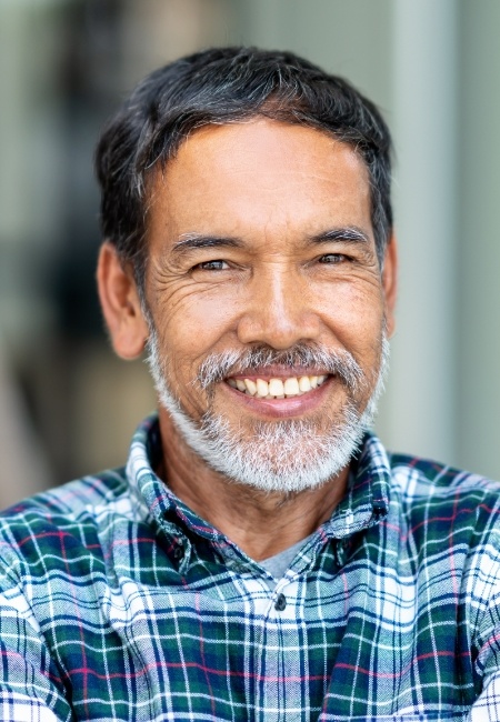 Man sharing flawless smile after dental crown and bridge restoration