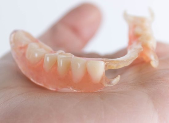 Hand holding partial dentures