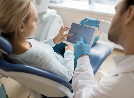 Dentist and patient reviewing treatment plan on tablet computer