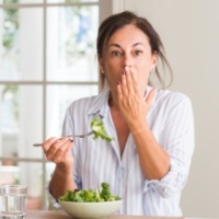 Woman with lost dental crown covering her mouth