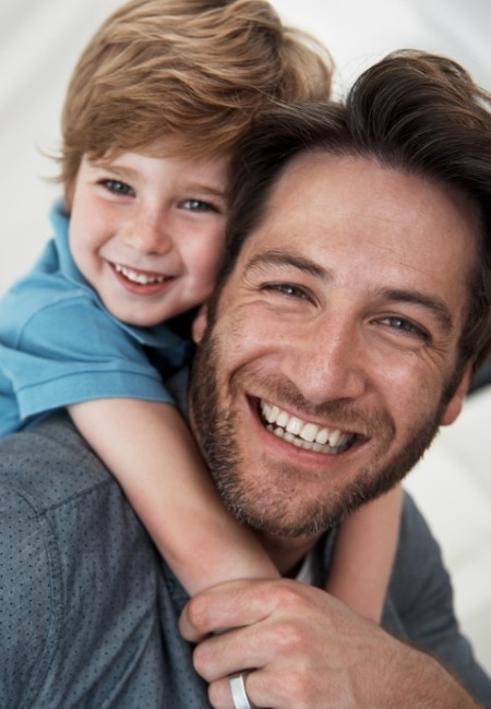 Father and child with healthy smiles after fluoride treatment
