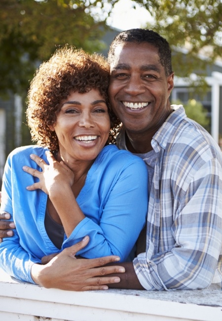 Smiling couple with dental implant supported dentures in Houston 