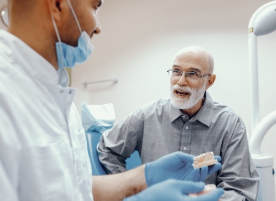 Man discussing the dental implant supported dentures process with dentist