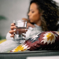 Woman drinking water after getting a dental implant in Houston