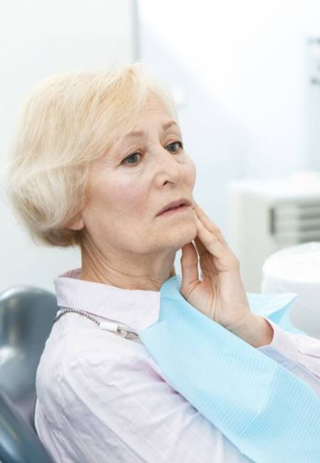 senior woman with a failed dental implant in Houston talking to her dentist 