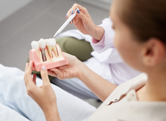 Dentist and patient discussing the four step dental implant process