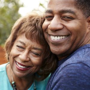 Man and woman smiling holding each other