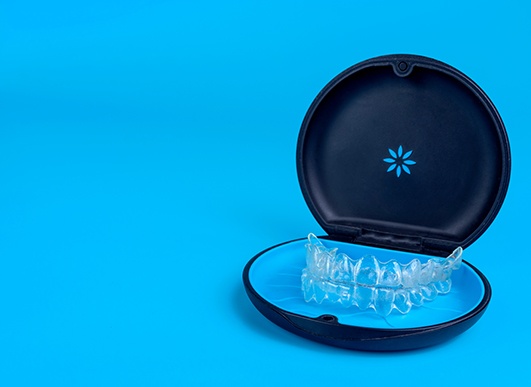 Invisalign trays in carrier case with light blue background