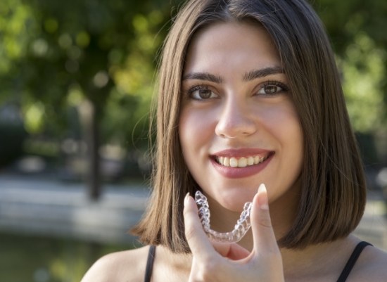 Woman holding an Invisalign tray