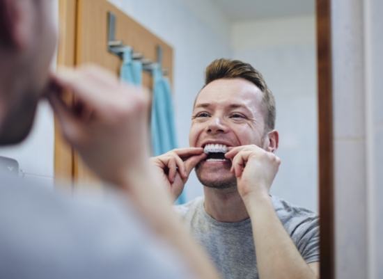 Man placing an Invisalign tray