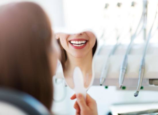 Woman with Lumineers looking at smile in mirror
