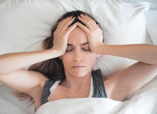 Woman in need of sleep apnea therapy waking feeling tired