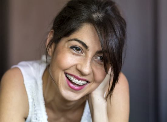 Woman with traditional orthodontics smiling