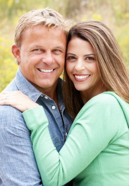 Man and woman smiling after periodontal splinting