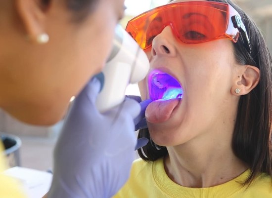 Dentist performing oral cancer screening