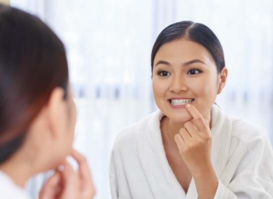 Woman looking at smile after gum disease treatment