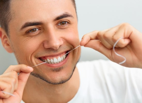 Man flossing teeth to prevent gum disease