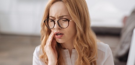 Woman in need of emergency dentistry holding jaw in pain