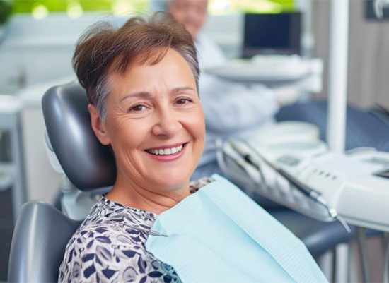 Smiling, mature dental patient in treatment chair
