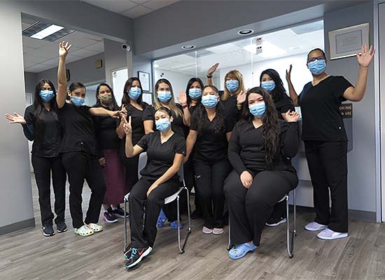 The Sunrise Dental Center team smiling and waving