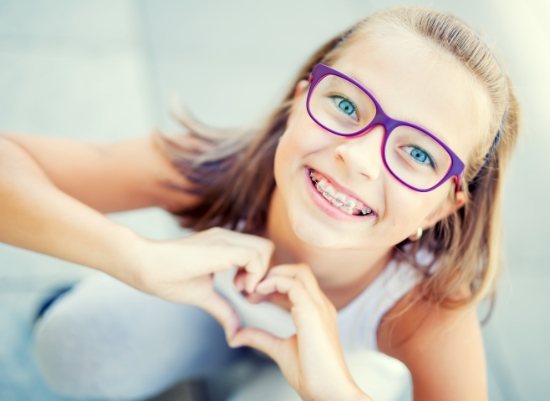 Young girl with traditional braces smiling