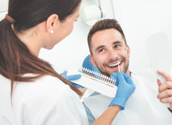Man discussing frequently asked porcelain veneer questions with dentist