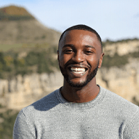 a man smiling and standing outdoors