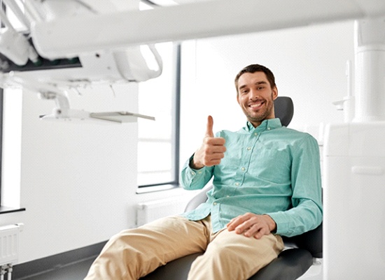 Happy dental patient giving thumbs up for X-Mark technology
