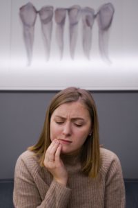 Woman in pain needing an emergency dentist.