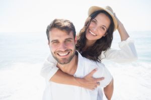 young couple on the beach after seeing their cosmetic dentist 