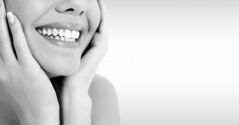 A grayscale picture of a woman smiling after treating her gray teeth