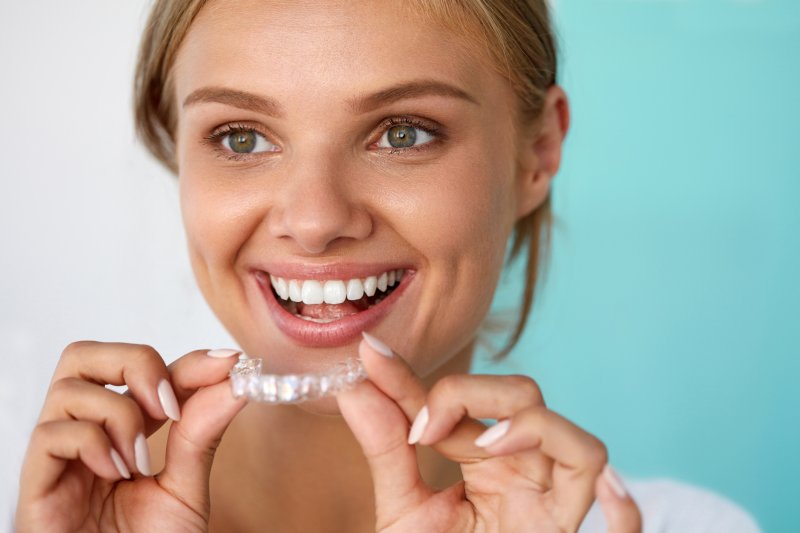 Patient smiling with their Invisalign aligner