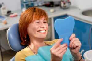 Woman smiling after getting dental implants